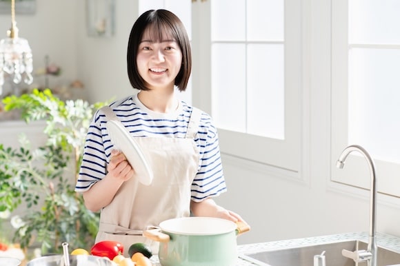 夕食のワンパターンを防ぐ方法 キッチンで笑顔を見せる女性